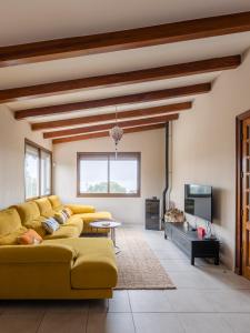 a living room with a yellow couch and a tv at Maison Mialon: country house amidst of nature in La Esperanza