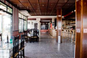 a dining room with tables and chairs in a restaurant at Hostal Hispalis in Gandul