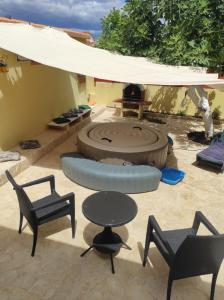 a patio with chairs and tables and a fire pit at LuMar Holidays and Apartments in Preko
