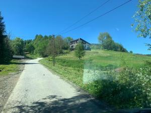 an empty road with a house on a hill at Apartamenty Pod Kątami in Kamienica