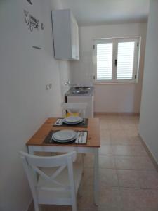 una pequeña cocina con una mesa de madera y una silla en Apartments Tony - near the sea, en Stomorska