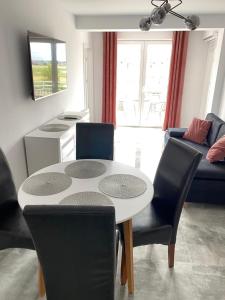 uma sala de estar com uma mesa e cadeiras e um sofá em Apartament Baltic Korona B20 em Darłowo