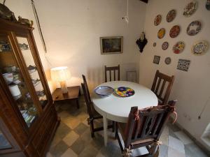 een eetkamer met een tafel en stoelen en borden aan de muur bij Guest House Bellaguarda in Altea