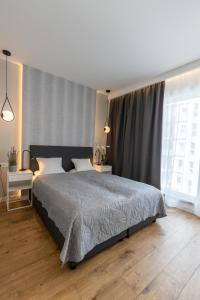 a bedroom with a large bed and a large window at Royal Family Apart metro Młociny in Warsaw