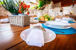una mesa con platos y servilletas en una mesa de madera en Villa Natura, en Pitve