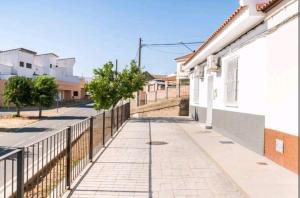 a sidewalk next to a fence next to a building at Paraíso rural con piscina in El Garrobo
