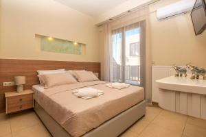 a bedroom with a bed and a bathroom with a sink at Fortezza Side Suite in Rethymno Town