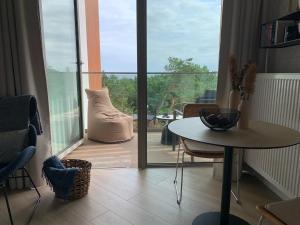 a room with a table and a view of a balcony at Pinea617 Seaview in Pobierowo