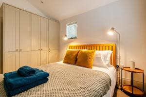 a bedroom with a bed with a blue pillow on it at Beautiful, central, 3 min walk from beach, 2 King doubles in Brighton & Hove
