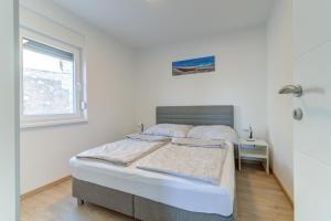 - une chambre avec 2 lits et une fenêtre dans l'établissement Damar Apartmani, à Senj
