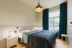 a bedroom with a bed with a blue blanket at Villa Fannyhof in Haapsalu