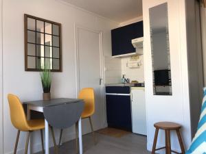 een kleine keuken met een tafel en gele stoelen bij Appt FOURAS Centre Ville 50m de la Mer in Fouras