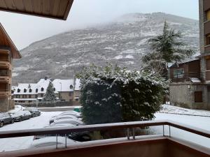 einen Balkon mit Blick auf einen schneebedeckten Berg in der Unterkunft Apartament reformat i acollidor a Vielha, ben ubicat in Betrén