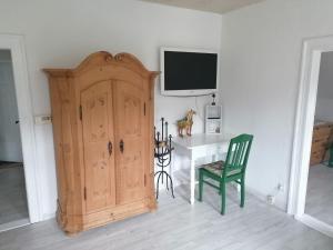 Im Herzen des Elbsandsteingebirges في كونيجشتاين آن دير إلب: غرفة فيها باب خشبي وطاولة وتلفزيون