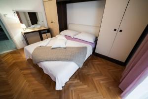 a small bedroom with two beds and a mirror at Villa Magdalena, Biograd na Moru in Biograd na Moru