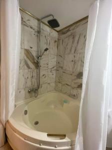 een badkamer met een bad, een toilet en een douche bij Eftihia di corfu in Corfu-stad