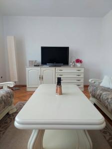 a living room with a white table and a tv at Dream in Otočac