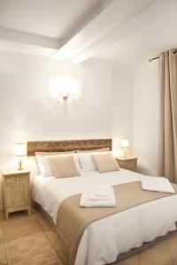 a white bedroom with a large bed with two lamps at Casa Letizia in Bologna