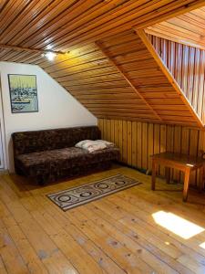 ein Zimmer mit einer Couch und einem Tisch auf einem Dachboden in der Unterkunft Casa Lorena in Sărata-Monteoru