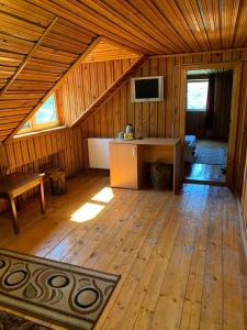 ein großer Raum mit Holzboden in einer Hütte in der Unterkunft Casa Lorena in Sărata-Monteoru