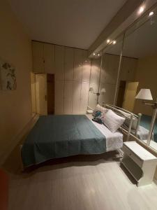 een slaapkamer met een bed en een grote spiegel bij Eftihia di corfu in Corfu-stad
