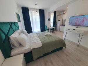 - une chambre avec un lit et un bureau avec un ordinateur dans l'établissement Grey Residence Apartments, à Tunari