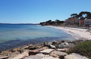 a view of a beach with rocks and the ocean at leflamantduport in Hyères