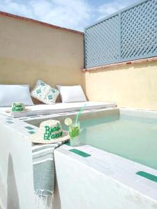 einen Pool mit 2 Betten und einem Getränk in der Unterkunft Riad El Arco ROOFTOP POOL & Spa in Marrakesch