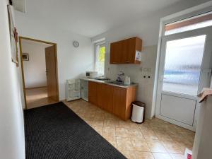 una pequeña cocina con fregadero y ventana en Privat HOTOS, en Liptovský Mikuláš