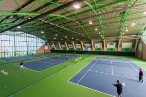 a tennis court with two people playing tennis at Hotel Gem in Wrocław