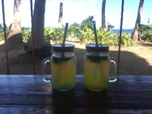 two mason jars sitting on a table near the beach at Harmony Healing Project - Connect With Your Divinity in El Nido