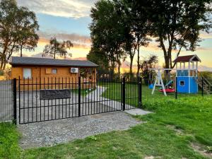 a black fence with a playground in a park at Black Horse in Pasłęk