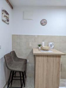 um balcão de cozinha com uma cadeira e um relógio na parede em Apartmani Drinska em Foca