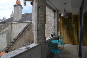 un balcón con 2 sillas y una mesa en un edificio en DNJ Appart Hotel en Meung-sur-Loire