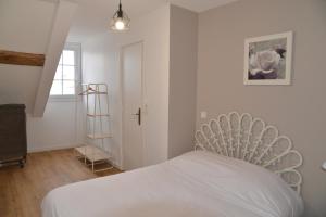um quarto com uma cama branca e uma escada em DNJ Appart Hotel em Meung-sur-Loire