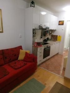 a living room with a red couch and a kitchen at STUDIO APARTMAN Marita in Split