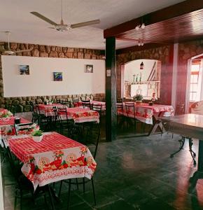 Pousada Canto da Praia في ساو بيدرو دا ألديا: مطعم بطاولات حمراء وكراسي ومرآة