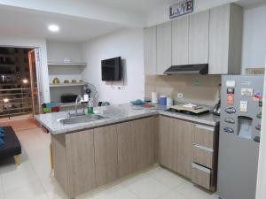 a kitchen with a sink and a refrigerator at Precioso apartamento con piscina y wifi in Girardot