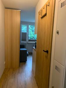 um corredor com uma porta e um quarto com uma cadeira em Pole Mokotowskie Apartament em Varsóvia