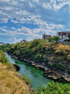 um rio com casas no topo de uma colina em Riverside Apartment em Podgorica