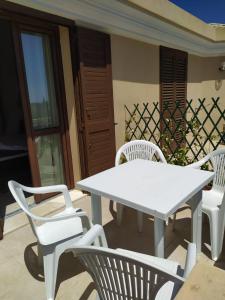 una mesa blanca y sillas en un patio en Villa Maria en Maracalagonis