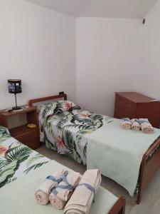 1 dormitorio con 2 camas y toallas. en Villa Maria en Maracalagonis