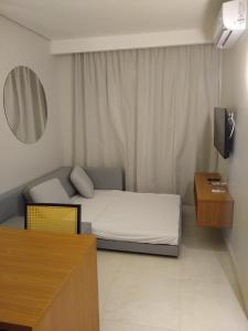 Dormitorio pequeño con cama y espejo en Salinas Exclusive Resort en Salinópolis