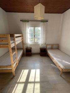 シダリにあるAlexey & Helga Houseの二段ベッド2台と窓が備わる客室です。
