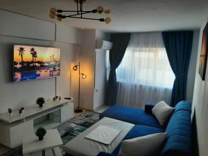 a living room with a blue couch in front of a window at Apartament DeltaView Deluxe Sulina in Sulina