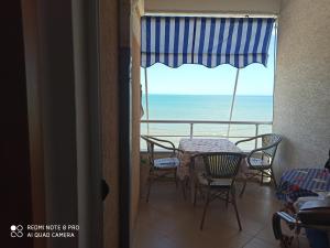 a room with a table and chairs and a view of the ocean at Isabel in Durrës