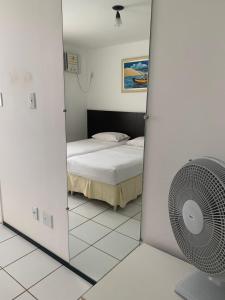 una camera con letto e ventilatore a specchio di GRAN LENÇÓIS FLAT - APTO PARTICULAR a Barreirinhas