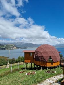 un pequeño edificio con una cúpula sobre un campo en Domos Lago Muisca Chia en Aquitania