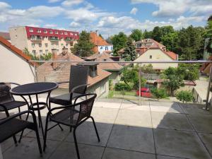 eine Terrasse mit Stühlen und einem Tisch auf dem Balkon in der Unterkunft Attic Apartment in Piešťany