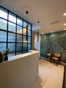 a lobby with a wall of windows and a tree mural at NoOne Tropea Guesthouse in Tropea